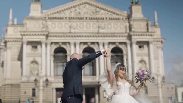 Novomanželé tančí v centru starého města. Nevěsta a ženich. Svatba — Stock video