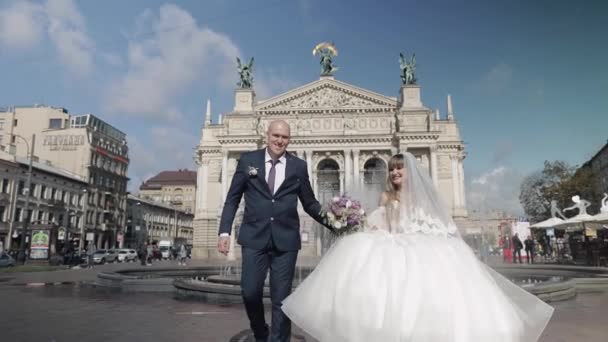 Nygifta promenader i centrum av gamla stan. Brud och brudgum. Bröllop — Stockvideo