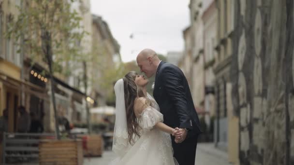 Nygifta i centrum av gamla stan. Brud och brudgum. Kyss mig. Bröllop — Stockvideo