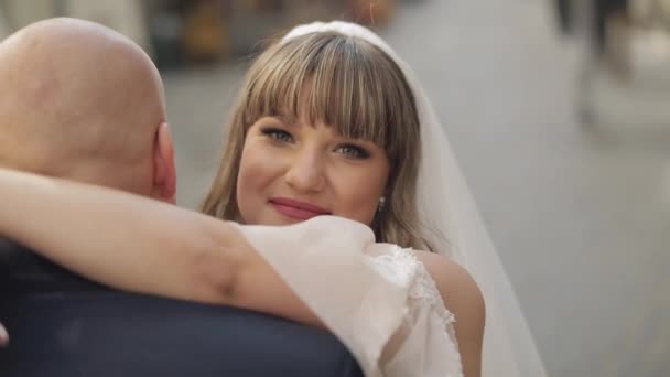 Novomanželé v centru města. Nevěsta objímá ženicha. Svatba — Stock video