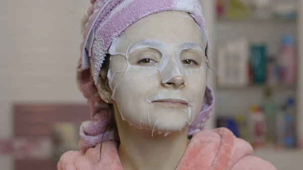 Woman applying cosmetic face mask in bathroom. Skincare spa. Facial mask — Stock Photo, Image