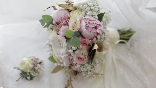 Beautiful wedding bouquets lie near window on white curtains — Stockvideo