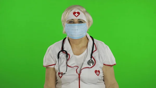 Elderly caucasian female doctor in protective mask. Pandemic. Coronavirus — Φωτογραφία Αρχείου