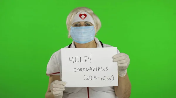 Elderly female doctor in medical mask show page with message. Coronavirus — Stockfoto