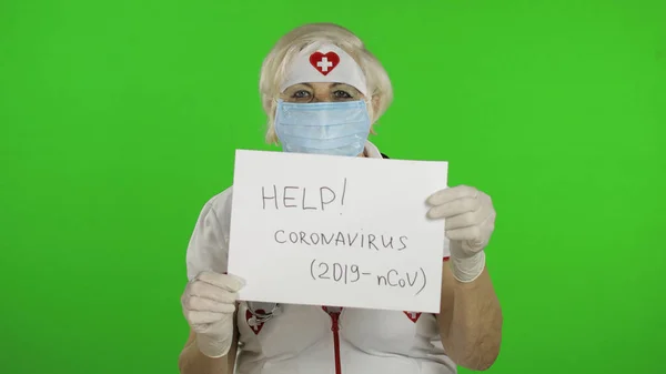 Elderly female doctor in medical mask show page with message. Coronavirus — Stockfoto