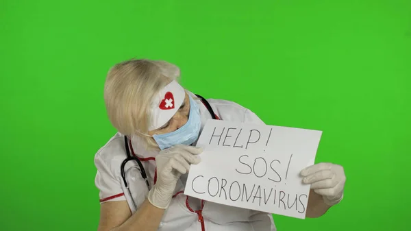 Elderly female doctor in medical mask show page with message. Coronavirus — Stok fotoğraf
