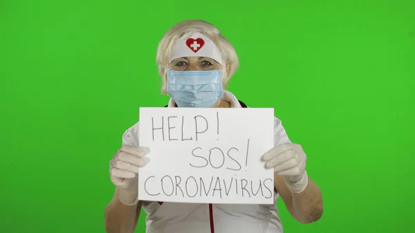 Elderly female doctor in medical mask show page with message. Coronavirus — Φωτογραφία Αρχείου