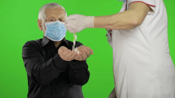 Hombre mayor con máscara de protección médica. El doctor da pastillas. Coronavirus — Foto de Stock
