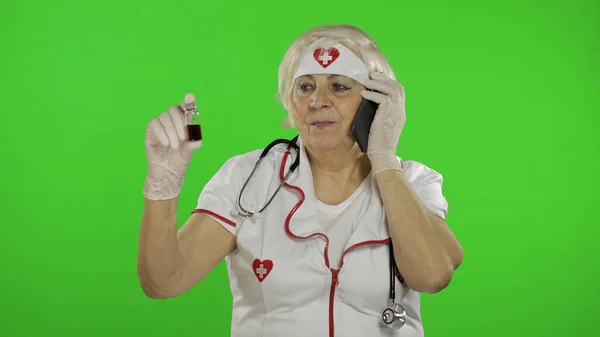 Elderly female doctor talking on the phone with patient. Coronavirus. Covid-19 — Stok fotoğraf