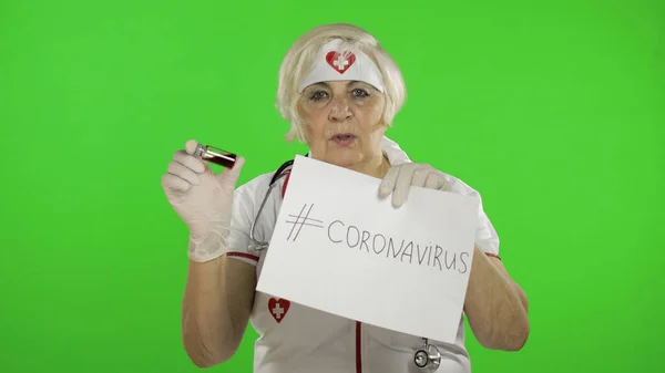 Elderly female doctor talking to camera. Test tube with analyzes. Coronavirus — Φωτογραφία Αρχείου