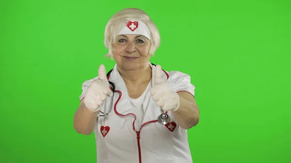 Elderly caucasian female doctor. Female nurse. Show OK sign. Thumbs up — Stockfoto