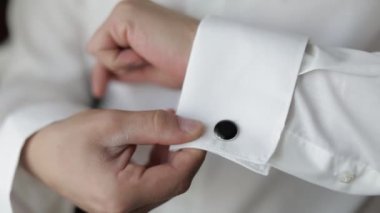 Yakışıklı damat adam kol düğmeleri ile bir ceket onun manşet düzeltir. Işadamı