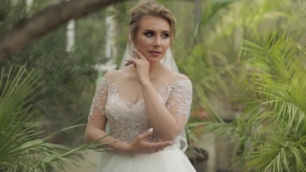 Krásná a krásná nevěsta ve svatebních šatech v parku. Zpomalený pohyb — Stock video