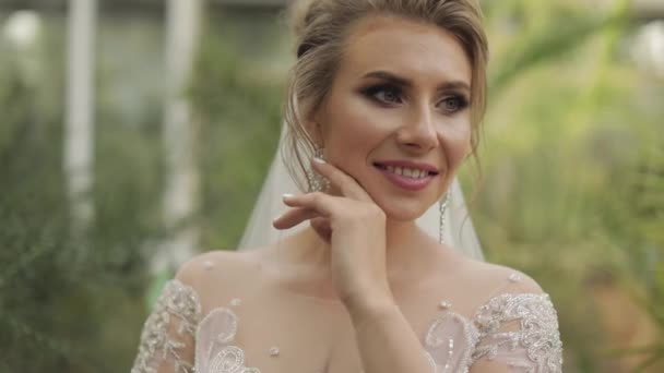 Krásná a krásná nevěsta ve svatebních šatech v parku. Zpomalený pohyb — Stock video