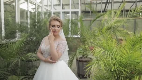 Hermosa y encantadora novia en vestido de novia en el parque. Movimiento lento — Vídeo de stock