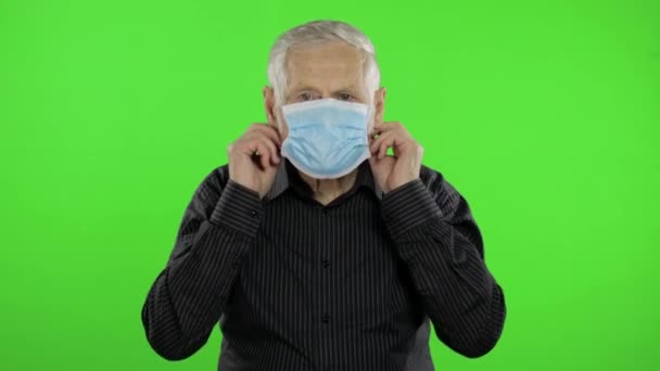 Elderly grandfather man in medical mask show page with message. Coronavirus — ストック動画