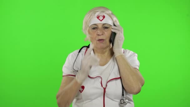 Doctora anciana hablando por teléfono con el paciente. Coronavirus. Covid-19 — Vídeo de stock