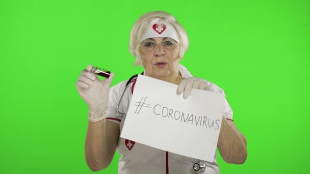 Elderly female doctor talking to camera. Test tube with analyzes. Coronavirus — ストック動画