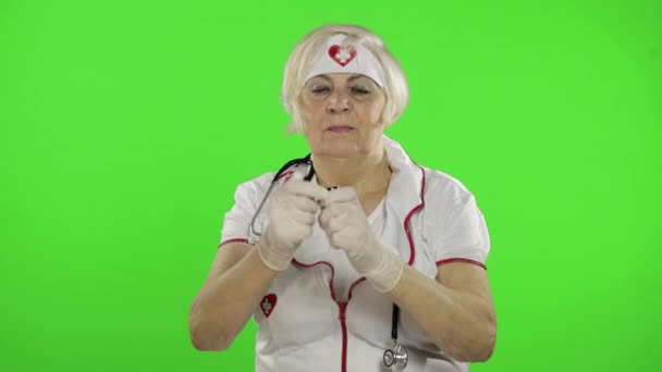 Пожилая женщина-врач наливает ей в руку таблетки. Женщина-медсестра. Защита вирусов — стоковое видео