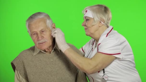 Зрелая медсестра врач осматривает пожилого пациента мужчина с проблемами — стоковое видео