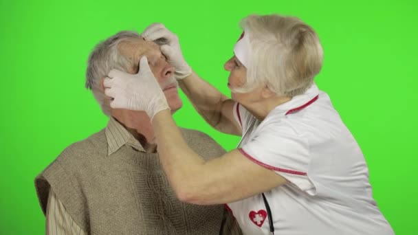 Mujer madura enfermera médico examina hombre paciente sénior con problemas — Vídeos de Stock