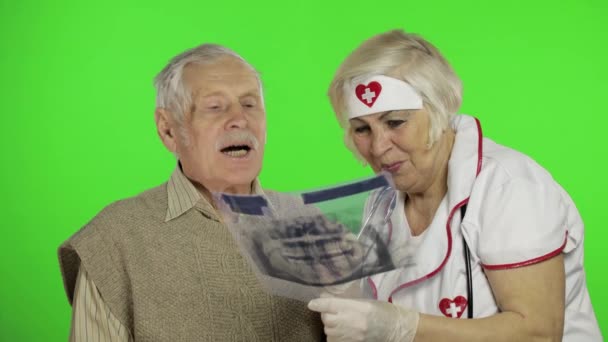 Mujer madura enfermera médico examina hombre paciente sénior con problemas — Vídeo de stock