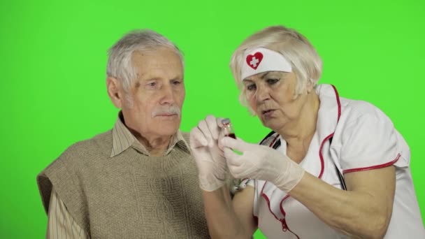 Mujer madura enfermera médico examina hombre paciente sénior con problemas — Vídeo de stock