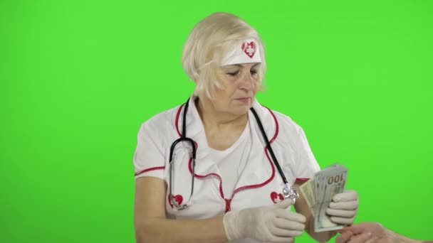 Пожилая белая женщина-врач получает деньги. Концепция коррупции — стоковое видео