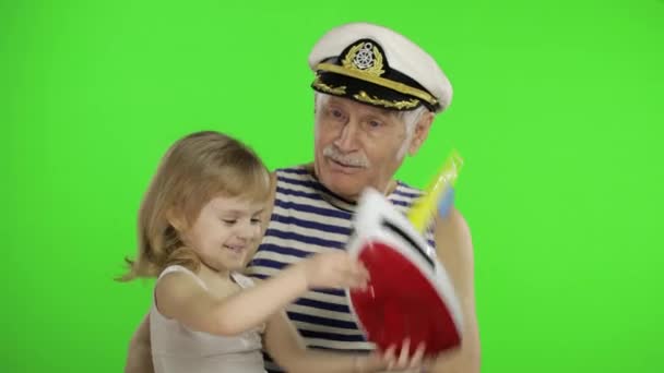 Elderly sailor man grandfather plays with granddaughter. Happy little child — 비디오