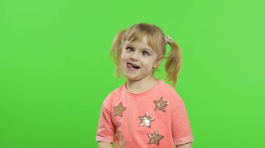 Olumlu kız duygusal olarak yüzler yapar ve pembe bluz içinde gülümser. Krom Anahtar