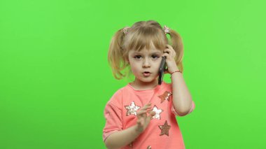 Akıllı telefon kullanan küçük bir kız. Çocuk cep telefonundan duygusal olarak konuşuyor