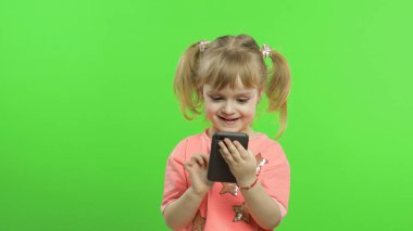 Akıllı telefon kullanan küçük bir kız. Akıllı telefondan mesaj atan, oynayan çocuk portresi