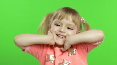 Olumlu kız duygusal olarak yüzler yapar ve pembe bluz içinde gülümser. Krom Anahtar