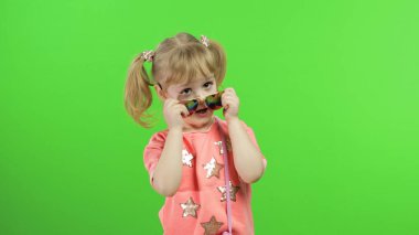 Pembe bluzlu, güneş gözlüklü, poz verip surat yapan pozitif bir kız. Krom Anahtar