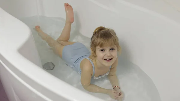 Nettes blondes Mädchen nimmt ein Bad in Badebekleidung. Kleines Kind, 4 Jahre alt. Hygiene — Stockfoto