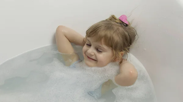 Nettes blondes Mädchen nimmt ein Bad in Badebekleidung. Kleines Kind, 4 Jahre alt. Hygiene — Stockfoto