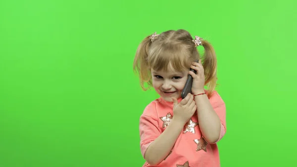 Egy kislány okostelefont használ. A gyermek érzelmileg beszél mobiltelefonon — Stock Fotó