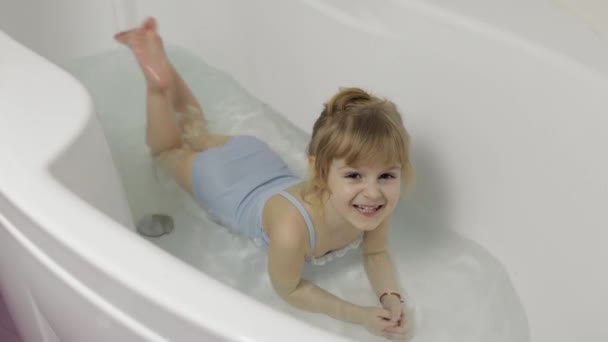 Nettes blondes Mädchen nimmt ein Bad in Badebekleidung. Kleines Kind, 4 Jahre alt. Hygiene — Stockvideo
