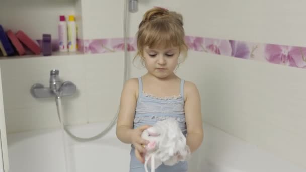 Jolie fille blonde prend un bain en maillot de bain. Petit enfant de 4 ans. Hygiène — Video