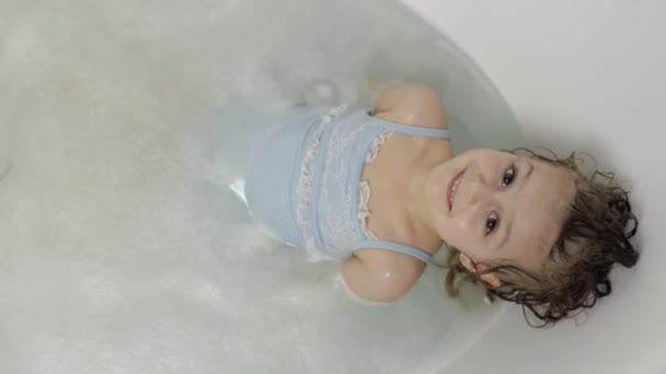 Cute blonde girl takes a bath in swimwear. Little child, 4 years old. Hygiene — Stock Video