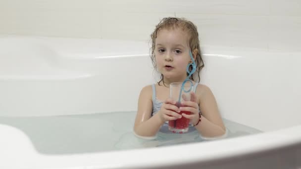 Carina ragazza bionda si fa un bagno in costume da bagno e bere un cocktail. Bambina. — Video Stock