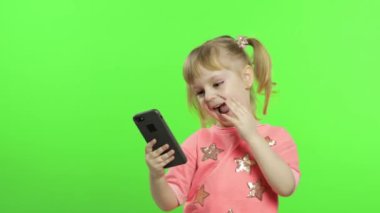Akıllı telefon kullanan küçük bir kız. Akıllı telefonlu çocuk fotoğraf ve selfie çekiyor.