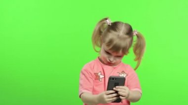 Akıllı telefon kullanan küçük bir kız. Akıllı telefonlu çocuk fotoğraf ve selfie çekiyor.