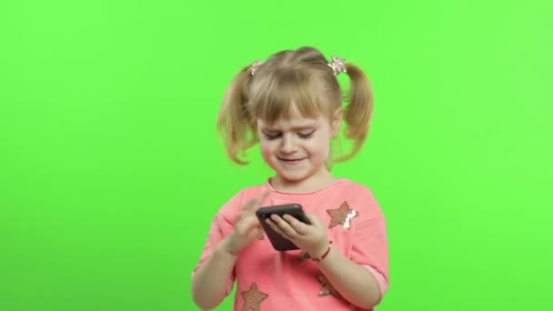 Μικρό κορίτσι που χρησιμοποιεί smartphone. Πορτρέτο του παιδιού με smart sms, αναπαραγωγή — Αρχείο Βίντεο