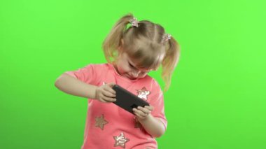 Akıllı telefon kullanan küçük bir kız. Akıllı telefondan mesaj atan, oynayan çocuk portresi