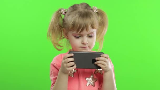 Gadis kecil menggunakan smartphone. Potret anak dengan SMS smartphone, bermain — Stok Video