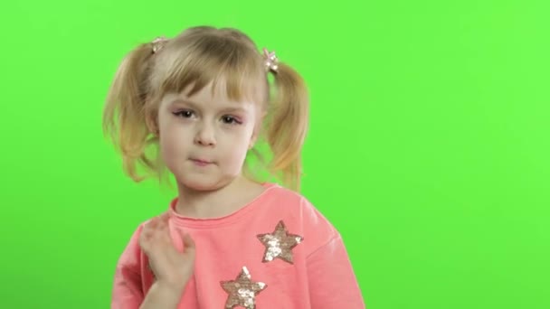 Una niña positiva con una blusa rosa agitando las manos y diciendo algo. Clave de croma — Vídeos de Stock