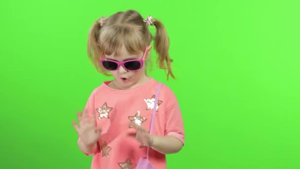 핑크 블라우스에 선글라스를 끼고 춤추고 포즈를 취하는 긍정적 인 소녀. 크로마 키 — 비디오