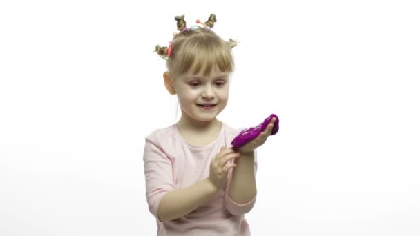 손으로 장난친 아이가 장난감 점액을 만들었습니다. 보라색 점액을 만드는 것을 즐기는 아이 — 비디오