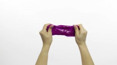 Kadın elleri garip bir şekilde tatmin edici mor balçık oynuyor. Beyaz arka plan. Stres önleyici